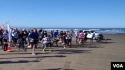 Runners set off from the beach during the inaugural "Race the Wave" 5K fun run/walk. VOA / T. Banse