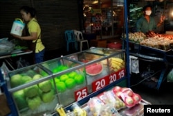 FILE - Street vendors sell food in a street in Bangkok, Thailand, Sept. 12, 2018.