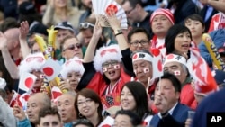Japan fans celebrate the 34-32 win against South Africa in the Rugby World Cup Pool B match at the Brighton Community Stadium in Brighton, England, Sept. 19, 2015.