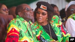 FILE - Zimbabwean President Robert Mugabe and his wife, Grace, follow proceedings during a youth rally in Marondera, about 100 kilometers east of Harare, June, 2, 2017. 