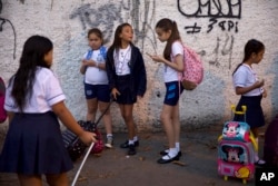 In this Feb. 4, 2019 file photo, students arrive for their first day of school, in Rio de Janeiro, Brazil. (AP Photo/Silvia Izquierdo)