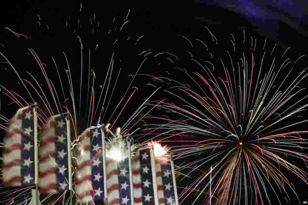 Umbul-umbul bermotif warna-warni bendera Amerika melambai-lambai saat kembang api raksasa menghias angkasa Lapangan Meadowlands, New Jersey, dalam perayaan Hari Kemerdekaan AS, 3 Juli 2012.&nbsp;