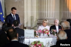 French President's wife Brigitte Macron and French singer Charles Aznavour listen to speeches at the start of an official state dinner with with Japan's Crown Prince Naruhito at the Chateau de Versailles castle, near Paris, France, Sept. 12, 2018.