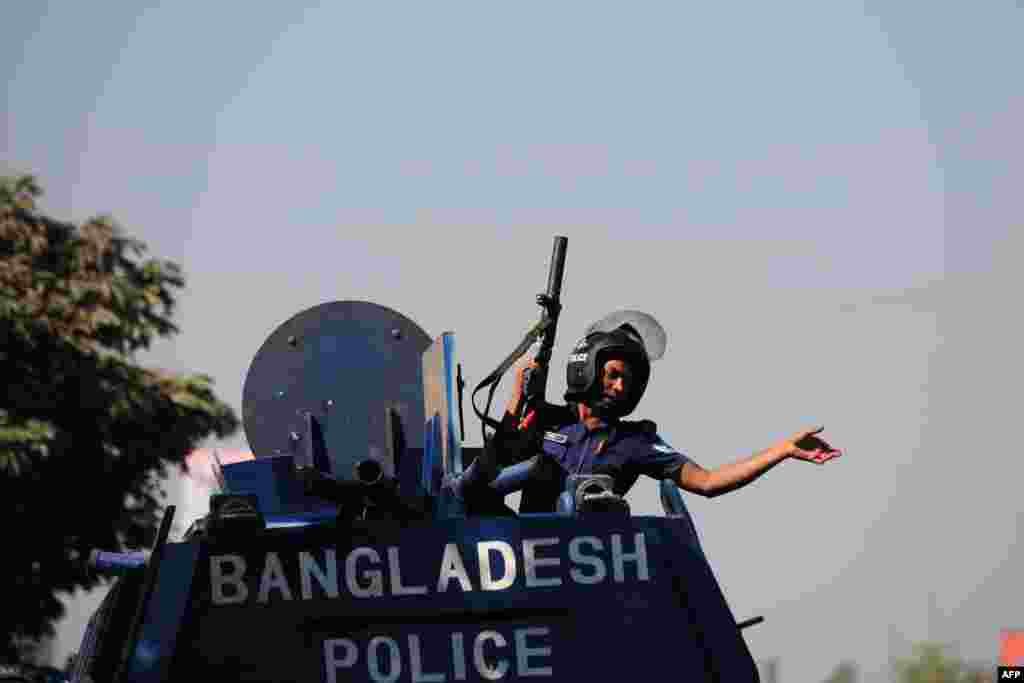 A police officer gestures from an armored car after clashes with Bangladesh Nationalist Party activists and its Islamist allies during a blockade in Aminbazar, on the outskirts of Dhaka, Nov. 26, 2013.