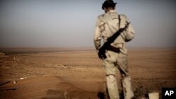 A Libyan rebel monitors Kadhafi loyalist forces as a sand storm sweeps the desert outpost of Twama, 30 km south-east of the western stronghold Zintan, on July 15, 2011. The lone outpost is the last defensive position of the rebels in the south of the Nafu