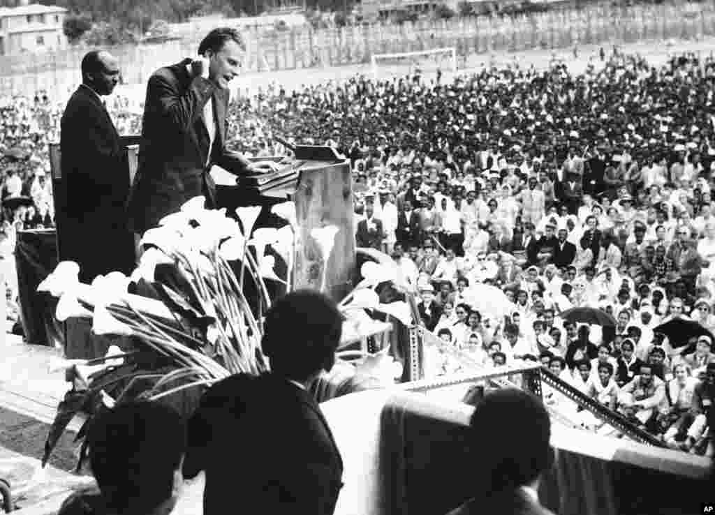 Billy Graham prêche devant une foule nombreuse dans un stade de football à Addis Abeba, Ethiopie, le 15 mars 1960.