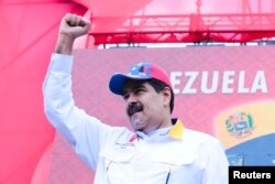 FILE - Venezuela's President Nicolas Maduro gestures during a rally with supporters in Caracas, March 23, 2019.