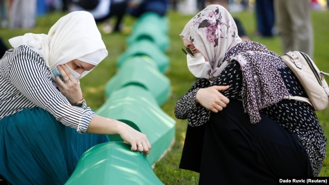 在波斯尼亚和黑塞哥维那斯雷布雷尼察附近的波托卡里，妇女们在家人的棺材旁哭泣。波斯尼亚纪念屠杀8000多名波斯尼亚穆斯林男子和男孩25周年。(2020年7月11日）