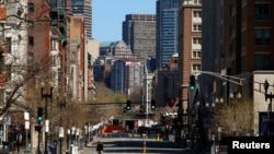 An investigator walks across Boylston Street near the site of the bombings in Boston, April 21, 2013.