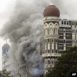 In this Saturday, Nov. 29, 2008 file picture, smoke billows from the landmark Taj Mahal hotel in Mumbai, India after an attack by gunmen.