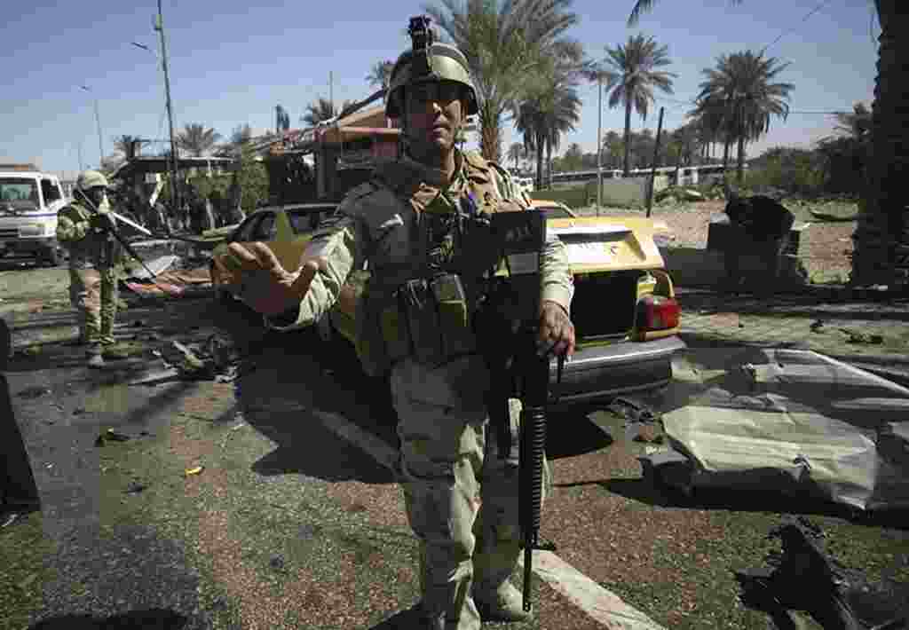 Pasukan keamanan Irak berjaga-jaga di tempat kejadian pemboman di Kerbala, sebelah selatan Baghdad (Reuters).