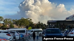 FILE - This May 2, 2021, photo shows smoke filling the sky as Sydney is enveloped in a thick bank of hazardous bushfire smoke, forcing authorities in Australia's largest city to scale back controlled forest burning nearby. 