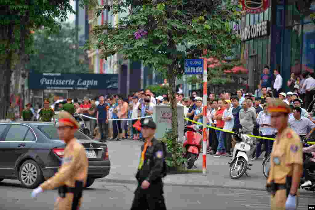 Warga berkumpul di jalan menunggu iring-iringan kendaraan yang membawa Presiden AS Barack Obama melewati sebuah jalan di Hanoi, Vietnam (23/5).