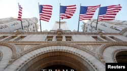 FILE - Flags fly above the entrance to the new Trump International Hotel on its opening day in Washington, DC, U.S. on Sept. 12, 2016. 