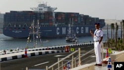 FILE - In this Thursday, Aug. 6, 2015, file photo, a cargo container ship crosses the new section of the Suez Canal after the opening ceremony in Ismailia, Egypt. In a few short years, if everything goes according to plan, Egypt will have new megaprojects, special investment zones and power plants fueled by the largest offshore gas field in the Mediterranean. But in the more immediate future, experts say the government needs to boost investment and bring in foreign capital to avoid a looming cash crunch. (AP Photo/Hassan Ammar)