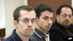 American hikers Shane Bauer (L) and Josh Fattal (C) and their translator attend the first session of their trial at the revolutionary court in Tehran, February 6, 2011