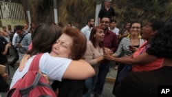 FILE - Relatives of political prisoners embrace as they wait for their release from the Heliciode prison in Caracas, Venezuela, June 1, 2018. 