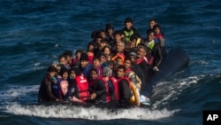 FILE - Afghan migrants on an overcrowded inflatable boat approach the Greek island of Lesbos in bad weather after crossing the Aegean Sea from Turkey, Oct. 28, 2015.