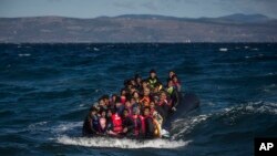 Emigrantes afganos en un sobrecargado bote se aproximan a la isla griega de Lesbos.