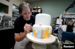 FILE - Baker, Jack Phillips, decorates a cake in his Masterpiece Cakeshop in Lakewood, Colorado, Sept. 21, 2017.