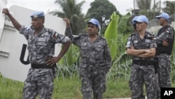 UN forces wait outside the UN headquarters during a press conference in Abidjan, Ivory Coast, Monday, Dec. 20, 2010.