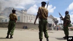 Armed police guard the Salvation Army Church after it was set on fire by rioting youths, following Friday Muslim prayers in Mombasa, Kenya, Oct. 4, 2013.