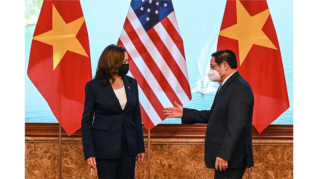 Perdana Menteri Vietnam Pham Minh Chinh (kanan) memberi isyarat kepada Wakil Presiden AS Kamala Harris di kantor Pemerintah di Hanoi, Vietnam, 25 Agustus 2021. (Manan Vatsyayana/Pool via REUTERS)