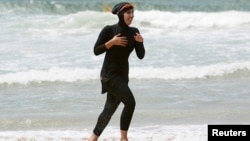 Twenty-year-old trainee volunteer surf life saver Mecca Laalaa runs burkini