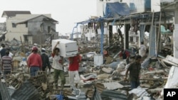 Tsunami survivors carry items they saved from a commercial area of Banda Aceh, the capital of Aceh province in northwest Indonesia. This photo was taken on December 31, 2004, five days after a tsunami destroyed the city and other coastal towns of Sumatra.