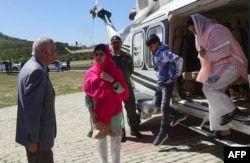 Pakistani activist and Nobel Peace Prize laureate Malala Yousafzai, center, meets with the principal, second left, of all-boys Swat Cadet College Guli Bagh, upon her arrival during her hometown visit, 15 kilometers outside of Mingora, March 31, 2018. Mala