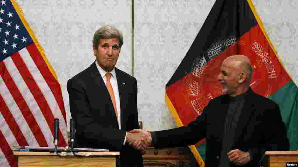 Menteri Luar Negeri AS John Kerry berjabat tangan dengan Presiden Afghanistan Ashraf Gani dalam konferensi pers di Kabul, Afghanistan (9/4). (Reuters/Mohammad Ismail)