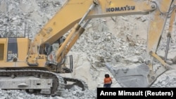 ARCHIVES - Rosalie Guiro Kulga, conductrice d'engins, pose pour une photo à côté de son excavateur sur le site d'une mine d'or exploitée par Endeavour Mining Corporation à Hounde, au Burkina Faso, le 11 février 2020.