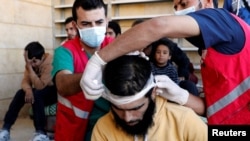 Medics treat civilians who were wounded at Raqqa's front line, at a mosque in Raqqa, Syria, Oct. 12, 2017. 