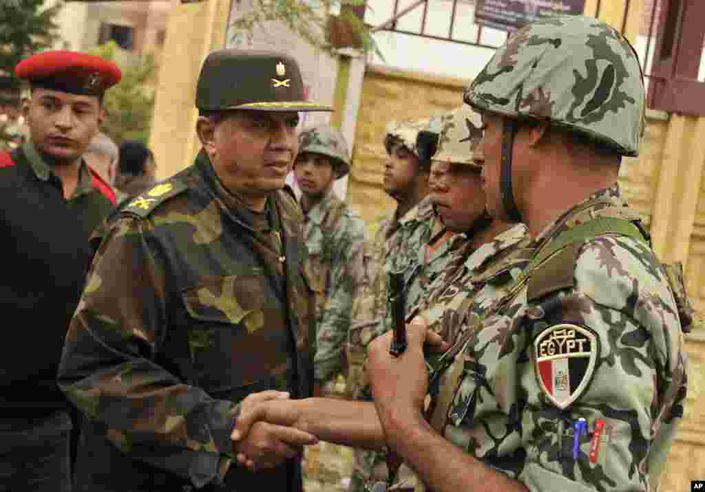 A Major General of the Egyptian Army shakes hand with soldiers after checking a polling station in Cairo, November 29, 2011. (AP)