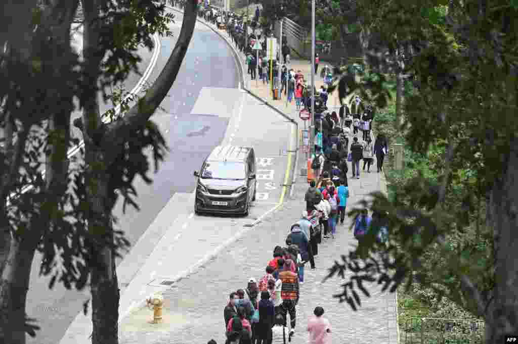 People queue at a mobile specimen collection station for COVID-19 testing in Hong Kong’s Tung Chung district, as authorities scrambled to ramp up testing capacity following a record high number of new infections.