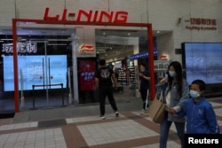 人們在北京一家商場走過一家李寧運動服裝品牌專賣店 （2021年4月15日）