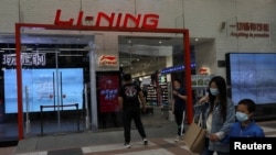人们走过北京街头的一家中国运动服装品牌李宁公司的专卖店。（2021年4月15日）