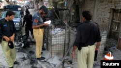 Policemen collect evidence outside a prison following a Taliban attack in Dera Ismail Khan, Pakistan, July 30, 2013. 