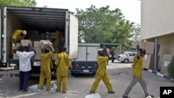 Electoral officers unload election materials from a vehicle at the Independent National Electoral Commission building in northern city of Kano, Nigeria, April 3, 2011