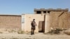 A Taliban solider stands guard in front of a house neighboring the Islamic State hideout raided by Taliban forces on Sunday night in northern Kabul, Afghanistan Oct. 4, 2021.
