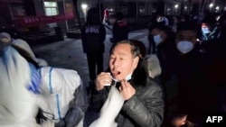 Para warga mengantre untuk menjalani tes asam nukleat untuk mengetahui apakah mereka terjangkit COVID-19 di salah satu lokasi tes di Kota Anyang, China, pada 8 Januari 2022. (Foto: AFP)