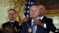 President Barack Obama presents Vice President Joe Biden with the Presidential Medal of Freedom during a ceremony in the State Dining Room of the White House in Washington, Jan. 12, 2017. 