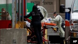 Un anciano enfermo es transportado en camilla a la sala de emergencias del hospital Elmhurst, Nueva York, sábado 28 de marzo de 2020. El hospital atiende a muchos enfermos de coronavirus en la ciudad. 