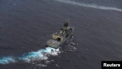 FILE - The Royal Australian Navy ship HMAS Perth is guided into position by a Royal New Zealand Airforce aircraft as the search continues for Flight MH370, April 13, 2014.