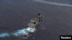 The Royal Australian Navy ship HMAS Perth is guided into position by a Royal New Zealand Airforce aircraft as the search continues for Flight MH370, April 13, 2014.