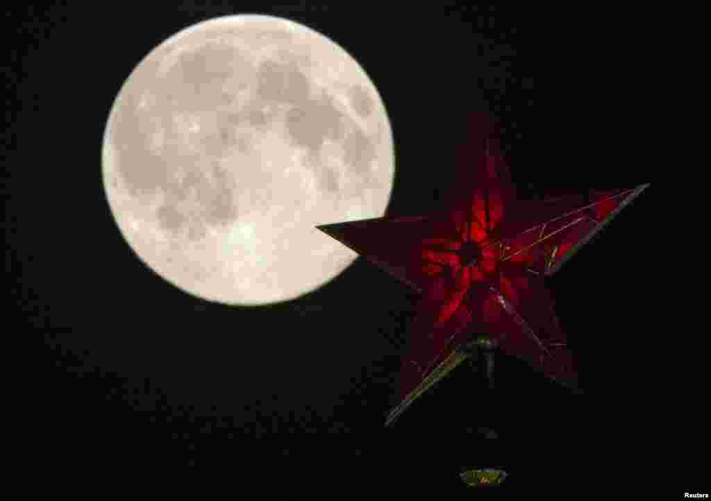 A supermoon rises over the stars of Moscow's Kremlin towers in Moscow, Aug. 10, 2014.