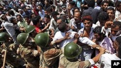 Yemeni army soldiers push back anti-government protesters during a demonstration demanding the resignation of Yemeni President Ali Abdullah Saleh, in Taiz, April 9, 2011