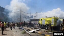 Polisi dan petugas pemadam kebakaran bekerja di lokasi ledakan di Aden, Yaman, 10 Oktober 2021. (Foto: REUTERS/Fawaz Salman)