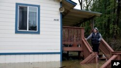 Amanda Hamner observa las aguas de las inundaciones del río Russian que rodea su casa en Forestville, California.