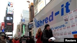 Seorang peserta melempar kertas berisi pesan yang ingin disobeknya pada acara "Good Riddance Day" di Times Square, New York, 28 Desember 2016.